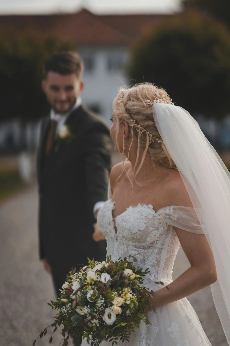 una sposa e uno sposo che camminano lungo una strada